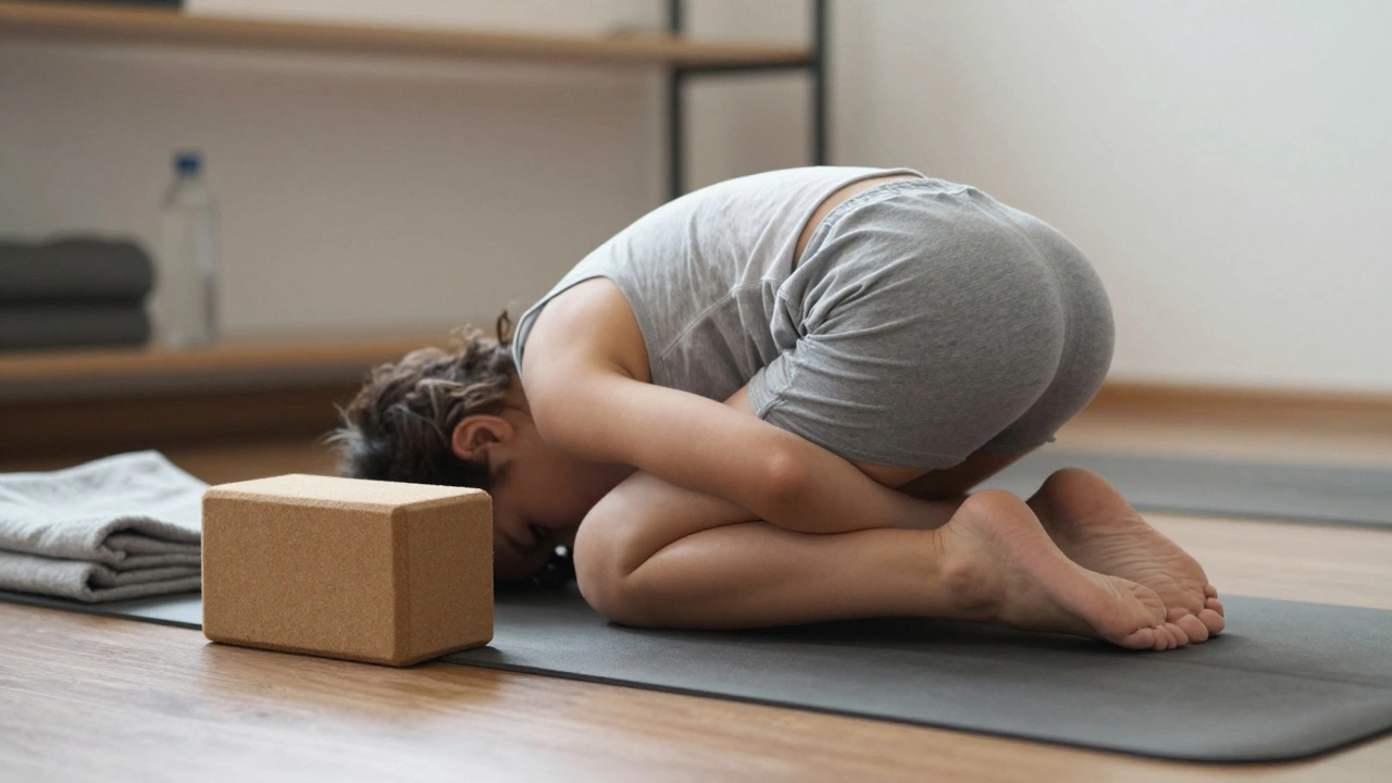 Close-up of someone in Child’s Pose with supportive props on a mat